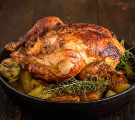 Roasted chicken with potatoes and onions in a cast iron pan